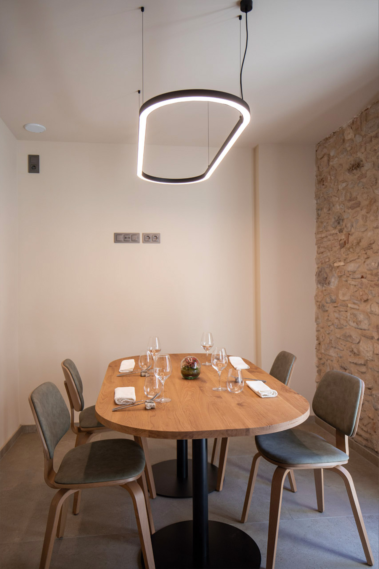 Luminaria ovalada en negro ilumina la mesa en una sala privada de un restaurante